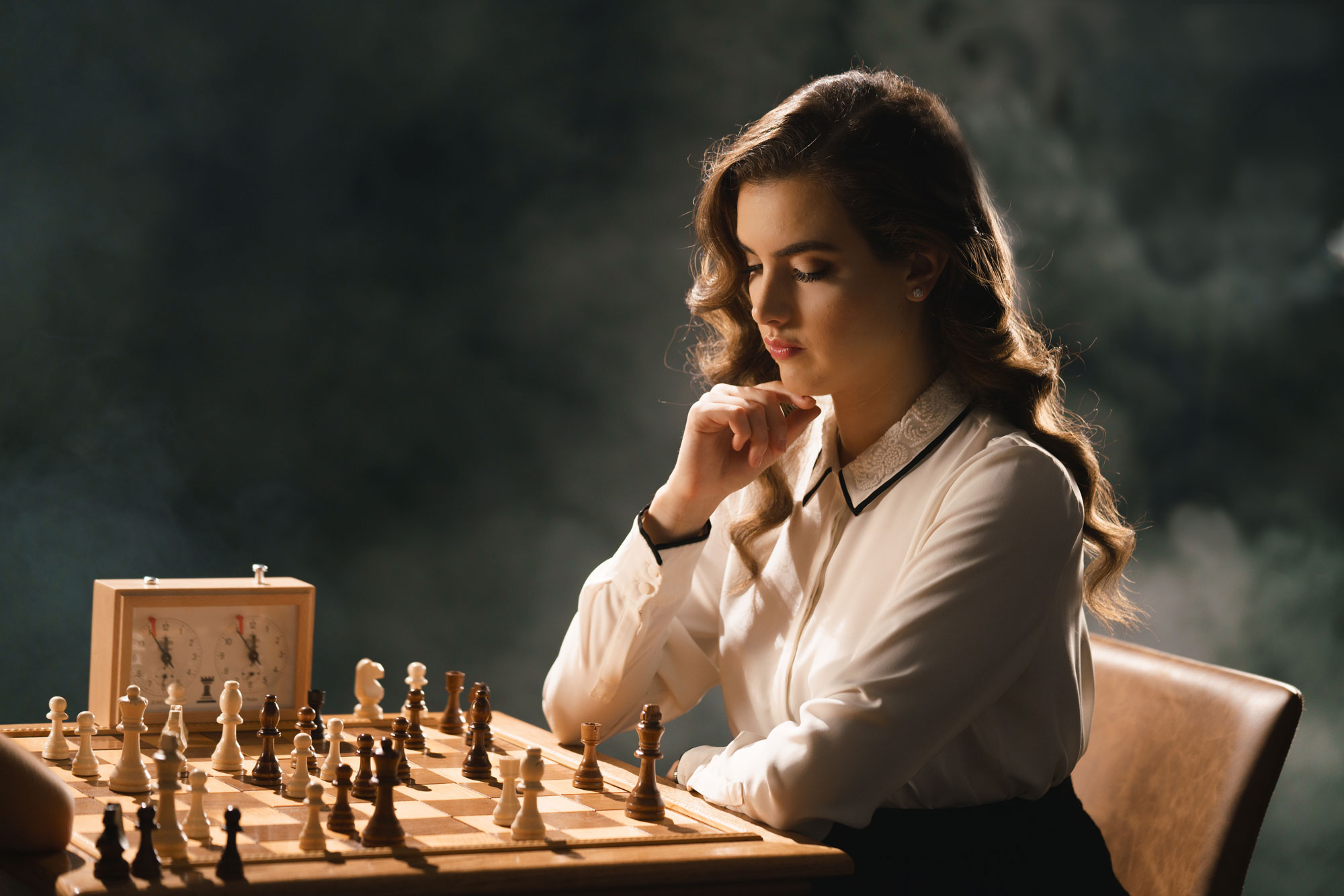 Alexandra Botez looking down at a chess board