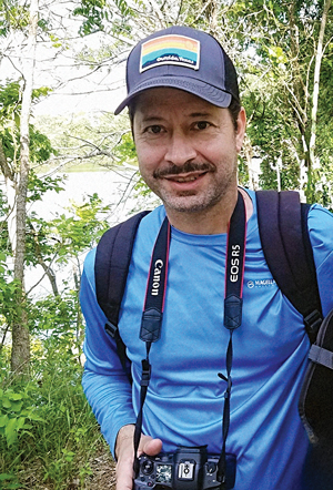 Juan Aguayo in the woods with a camera around his neck