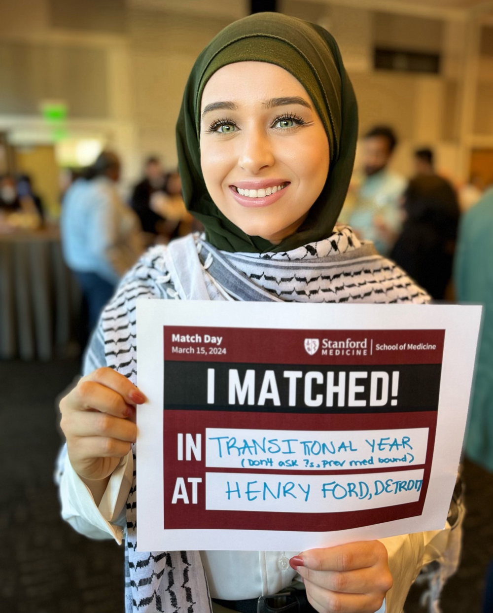 Headshot of Jawad holding a sign that says "I Matched."