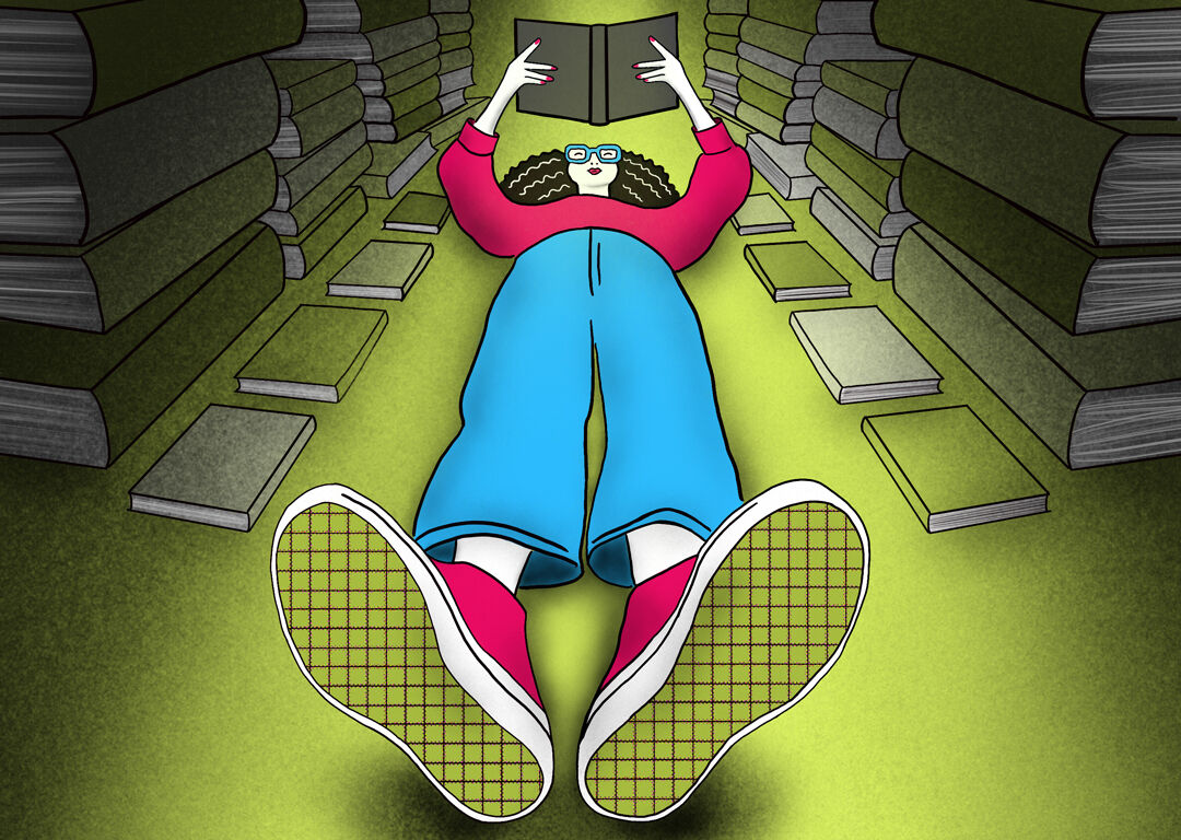 A person lying down both reading and surrounded by books