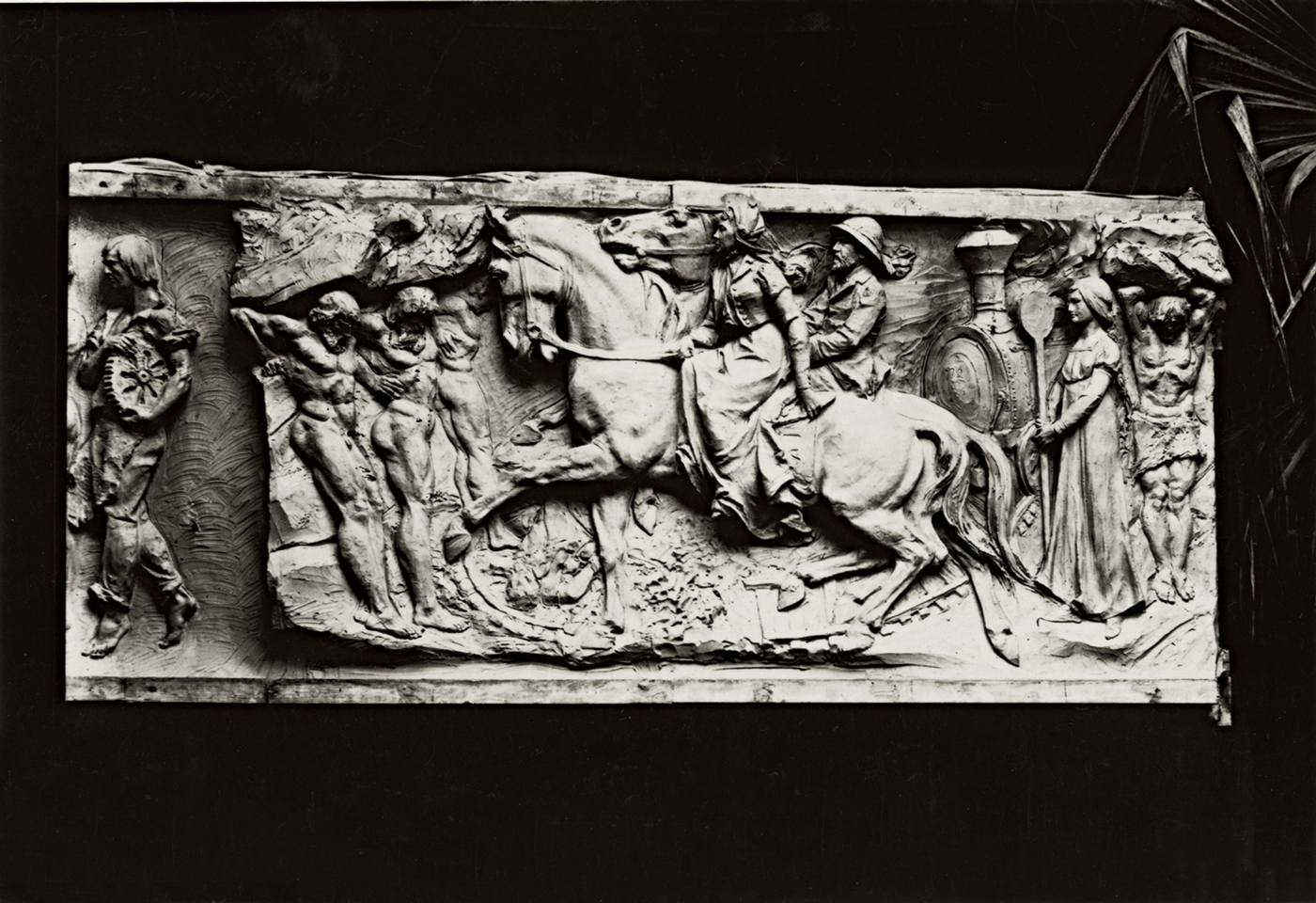 A metallic mural with a mixture of Grecian and modern style. Muscled men are seen throughout, though there is a more modern gentleman to the left and a woman on the right. In the middle are Leland and Jane Stanford on a horse.