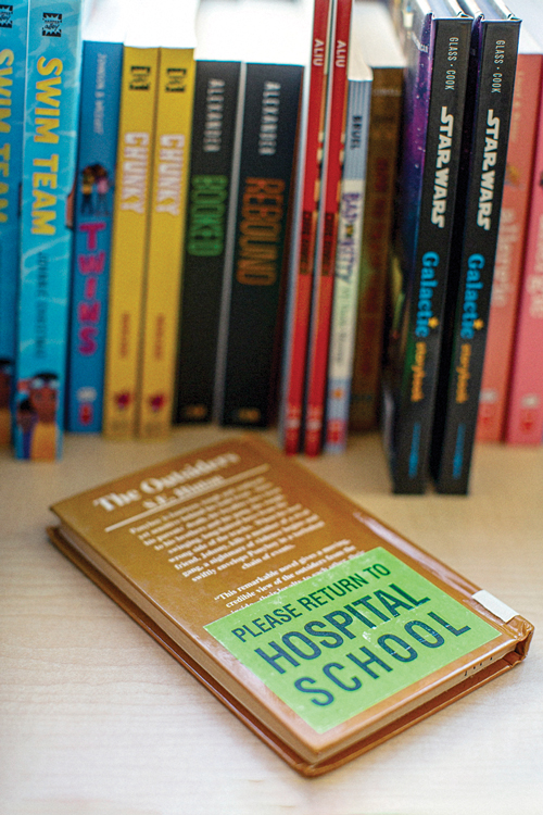 Books standing and one book lying down on a surface
