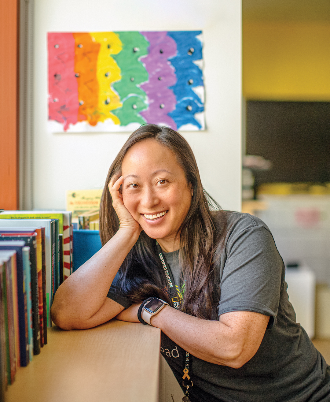 A smiling Kathy Ho sitting near books