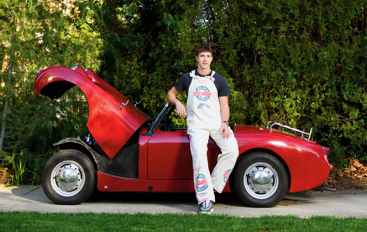 Greene in front of a red sports car