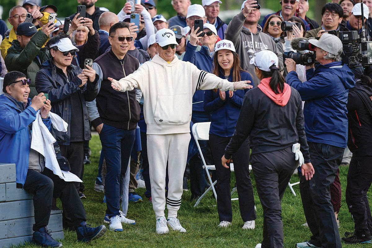 Zhang's father, Henry with open arms to Zhang while cameras and fans look on.