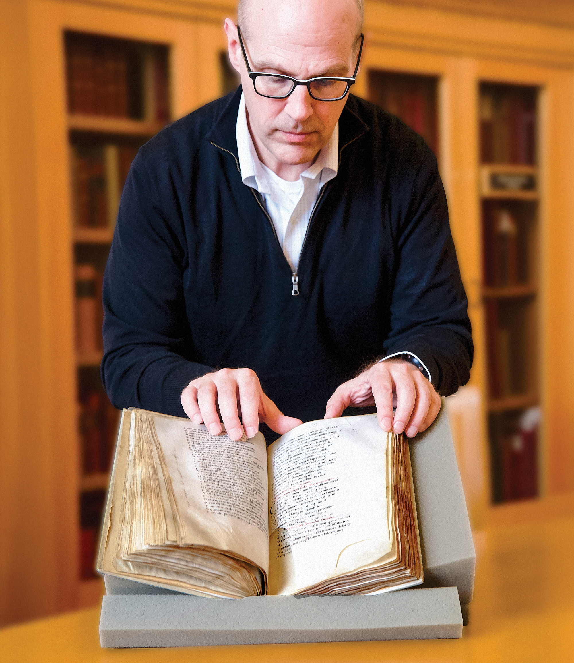 Benjamin Albritton looking through a rare book