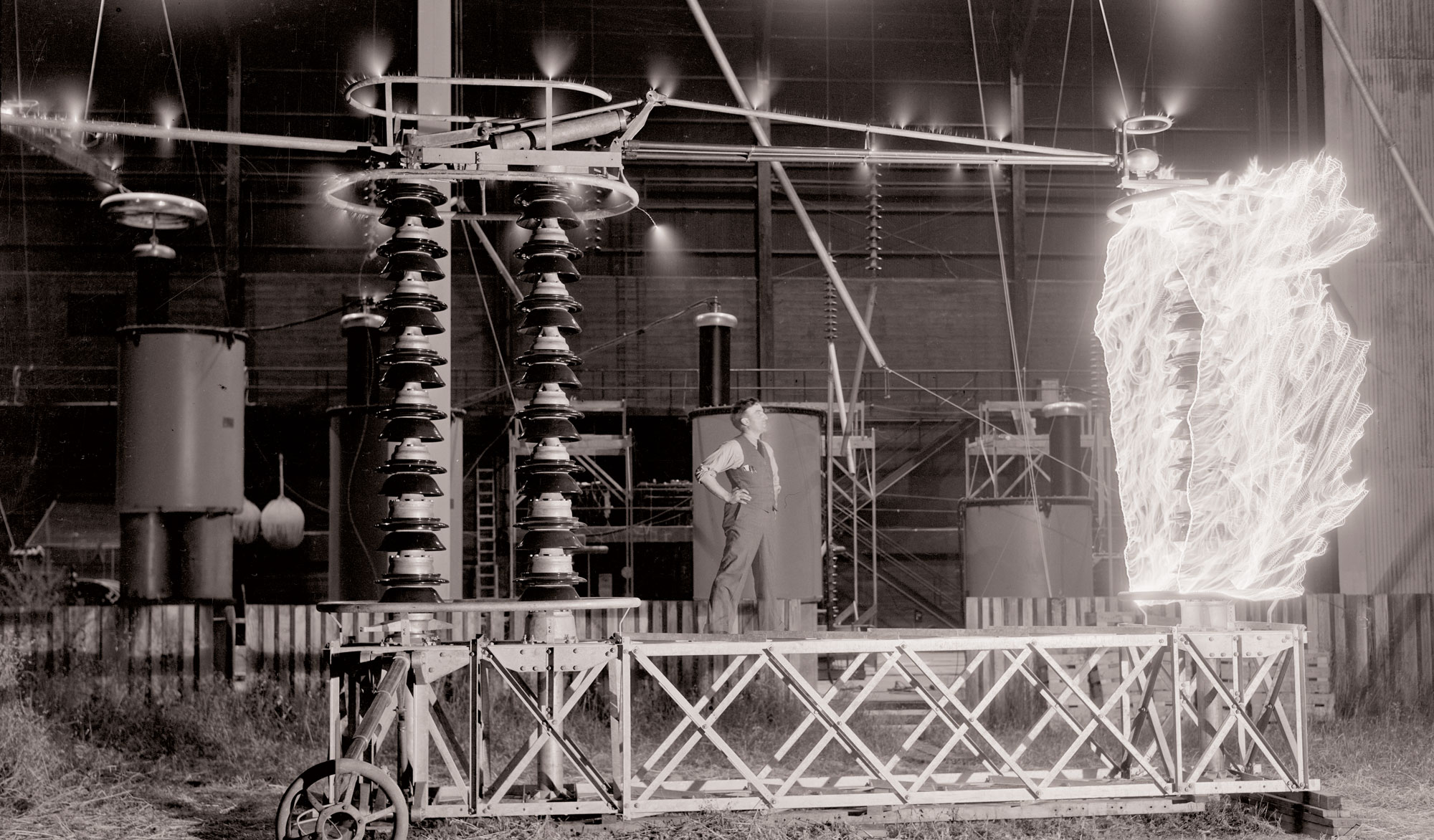A vintage photo from around 1926. A man staring at a high voltage image that looks like a flame.