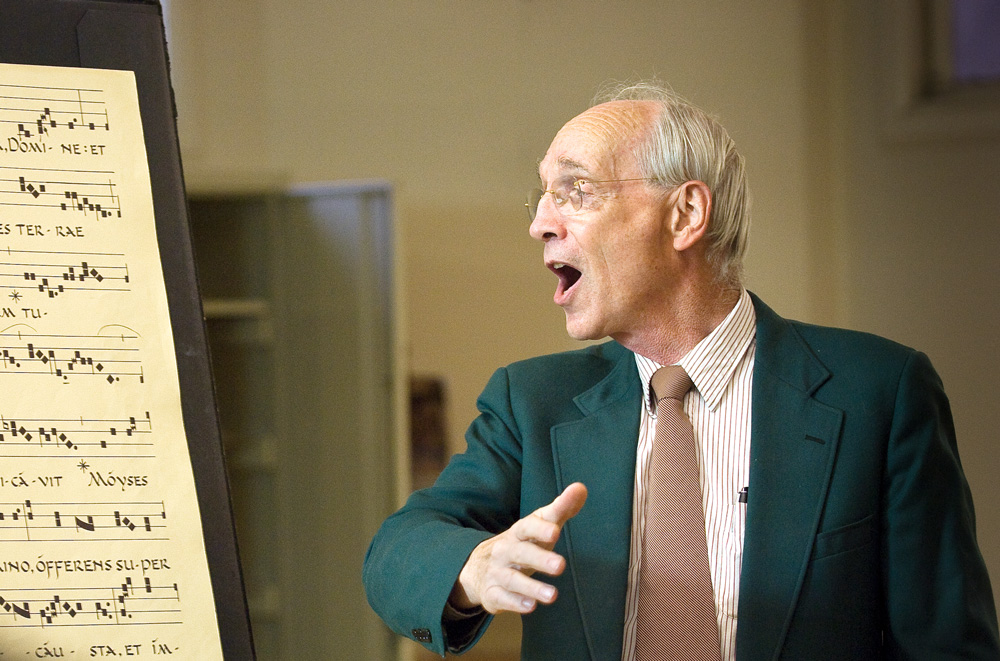 William Mahrt singing next to a music stand with sheet music on it