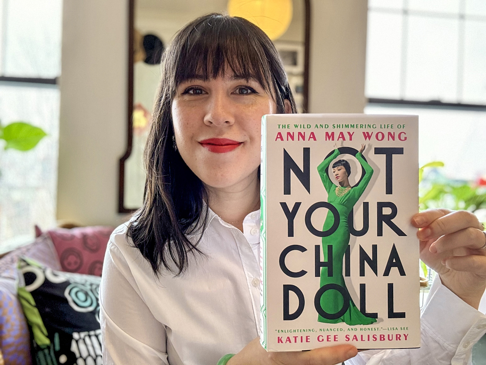 Katie Gee Salisbury holding up the book "Not Your China Doll."