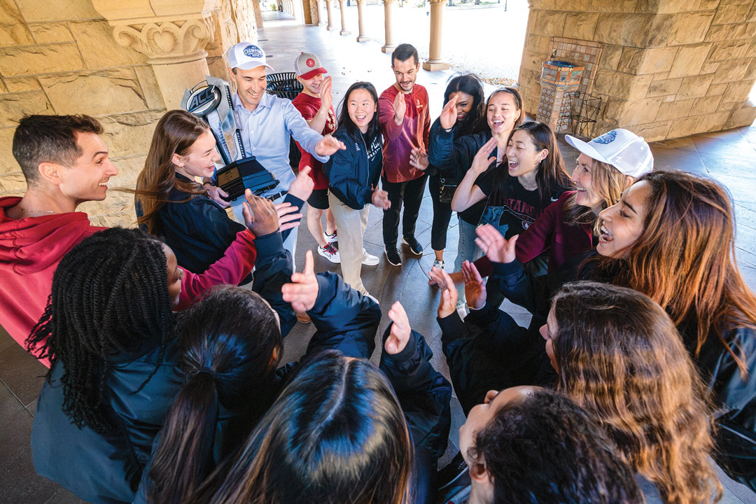 Students and Jon Levin holding an ACC trophy standing in a circle 