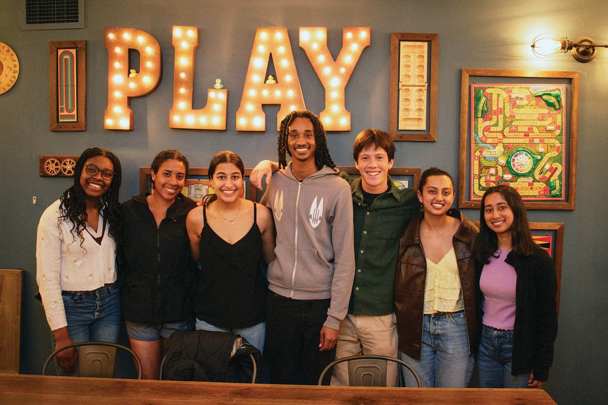 Students standing in front of a sign that reads Play.